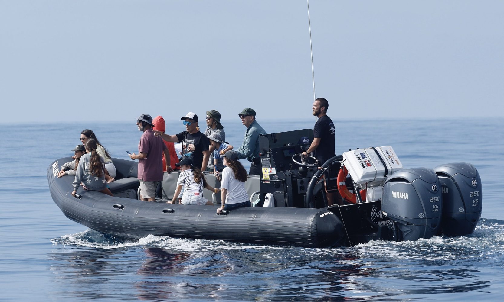 Group of people on a motorboat in calm ocean waters.