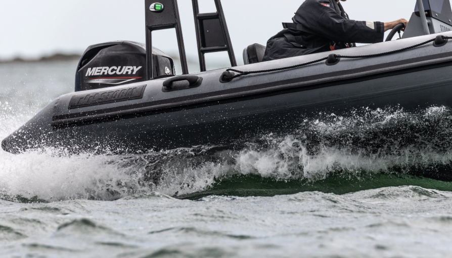 Close-up of a black motorboat in motion on the water.